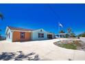 Brightly colored single-story home with a long driveway and well-manicured lawn at 741 W Perry St, Englewood, FL 34223
