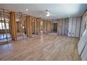 Open-concept living room under construction with wood-look tile flooring and exposed studs at 741 W Perry St, Englewood, FL 34223