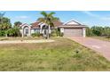 Charming single-story home featuring a manicured lawn and a two-car garage at 8251 Arlewood Cir, Port Charlotte, FL 33981