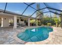 Screened-in pool with spacious patio, an outdoor dining area, hot tub and lush landscaping providing a private backyard oasis at 8251 Arlewood Cir, Port Charlotte, FL 33981