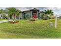 Home exterior showcasing a verdant lawn, mature palm trees, and tasteful landscaping, enhancing its curb appeal and serene setting at 8304 Antwerp Cir, Port Charlotte, FL 33981