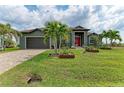 Home exterior with a lush green lawn adorned with palm trees and decorative planters, creating a welcoming and well-maintained entrance at 8304 Antwerp Cir, Port Charlotte, FL 33981