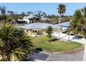 Aerial view of the yellow single-Gathering home with a two-car garage at 840 Park Rd, Englewood, FL 34223