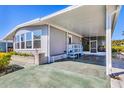 Home with a carport, screened-in lanai, and charming blue bench seating at 985 Jolanda Cir, Venice, FL 34285