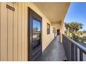 Exterior condo entrance featuring a black door and walkway with nice lighting and a glimpse of tropical greenery at 14459 River Beach Dr # 122, Port Charlotte, FL 33953