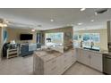 Open-concept kitchen with marble countertops, stainless steel appliances, and a seamless flow to the living area at 1490 Janet Pl, Englewood, FL 34223