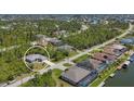 Aerial view of a single-Gathering home in a wooded area with canals and other houses nearby at 15613 Alsask Cir, Port Charlotte, FL 33981