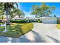 Charming single-story home with well-manicured lawn, mature landscaping, and a two-car garage at 1648 Shelburne Ln, Sarasota, FL 34231
