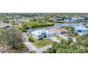 High-angle view of a property with canal access and dock, surrounded by lush green landscapes at 18610 Ayrshire, Port Charlotte, FL 33981
