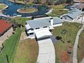 An aerial view of a charming waterfront property with a private boat dock, lush landscaping, and a covered parking area at 202 South Dr, Englewood, FL 34223