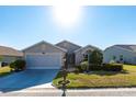 Inviting home featuring lush landscaping, well-maintained lawn, and an attached two-car garage at 24135 Buckingham Way, Punta Gorda, FL 33980
