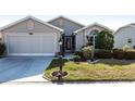 Charming home featuring a two-car garage, meticulous landscaping, and a welcoming entrance at 24135 Buckingham Way, Punta Gorda, FL 33980