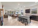 Open kitchen and living area with breakfast bar, tile floors and view of the living area at 2572 Sherman Oak Dr, North Port, FL 34289