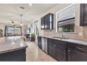 Spacious kitchen with dark cabinetry, granite counters, and an adjacent living area at 2572 Sherman Oak Dr, North Port, FL 34289
