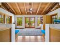 Inviting living room with vaulted ceilings, wood beams, and natural light flooding through large windows and doors at 2760 Lemon Ave, Englewood, FL 34223