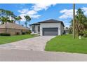 Charming single-Gathering home boasting a well-manicured lawn and attractive brick paver driveway at 280 Antis Dr, Rotonda West, FL 33947