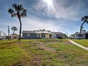 A scenic backyard view of a single story house surrounded by lush greenery and palm trees at 408 S Mccall Rd, Englewood, FL 34223