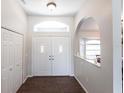 Bright foyer with tile floors, double front doors, and a view into the dining area at 52 Mariner Ln, Rotonda West, FL 33947