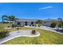 Charming home featuring a well-manicured lawn, elegant landscaping, and a beautiful, freshly-painted exterior at 62 Oakland Hills Pl, Rotonda West, FL 33947