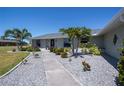 Inviting home featuring lush landscaping, a serene yard, and a pristine, freshly-painted exterior at 62 Oakland Hills Pl, Rotonda West, FL 33947