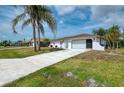 Charming home featuring a two-car garage, well-maintained lawn, and mature palm trees at 7215 Brookhaven Ter, Englewood, FL 34224