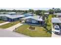 Charming single-story mobile home with a carport, verdant lawn and tropical palm trees at 816 Tangerine Woods Blvd, Englewood, FL 34223