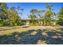 Charming single-story home featuring a well-maintained lawn, tropical landscaping, and a modern metal roof at 850 Van Gogh Road, Englewood, FL 34223