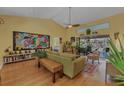 Bright living room with high ceilings, large colorful art piece and view of the pool area at 850 Van Gogh Road, Englewood, FL 34223