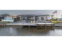 Beautiful waterfront home with a screened-in lanai and boat dock with chairs for relaxing at 9214 Melody Cir, Port Charlotte, FL 33981