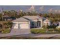 Charming one-story home with stone accents, a three-car garage, and a meticulously manicured lawn at 9214 Melody Cir, Port Charlotte, FL 33981