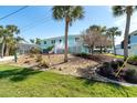 Exterior of bright home with palm trees, nicely manicured landscaping, and a well-kept lawn at 9230 Pine Cove Dr, Englewood, FL 34224