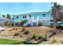 Exterior of a home with a gray driveway and a blue and white color scheme, accented by green palm trees at 9230 Pine Cove Dr, Englewood, FL 34224