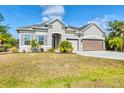 Attractive single-Gathering home featuring tidy landscaping, and a spacious two-car garage at 9283 Impala Cir, Port Charlotte, FL 33981