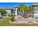 Close up of front door with stone and manicured landscaping around the walkway at 10039 Sunday Dr, Port Charlotte, FL 33981