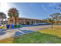 Low angle of a condominium with a parking area and palm trees at 11 Quails Run Blvd # 9, Englewood, FL 34223