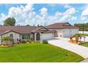 Well-maintained front yard with lush green grass, updated landscaping, and an expansive three-car garage at 11101 Sandrift Ave, Englewood, FL 34224