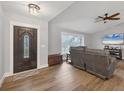 Cozy living room with wood floors, a decorative front door and a ceiling fan at 11101 Sandrift Ave, Englewood, FL 34224