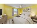 Comfortable bedroom boasts a ceiling fan, window views, and stylish decor at 1160 Sharlo Cir, Englewood, FL 34224