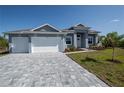 Well designed driveway leading up to a three-car garage, with manicured landscaping at 14526 Fort Worth Cir, Port Charlotte, FL 33981