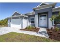 Close up of the front entrance, landscaping, and a three-car garage on a single-story home at 14526 Fort Worth Cir, Port Charlotte, FL 33981