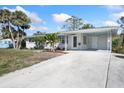 Beautiful home with a covered porch featuring decorative columns, ceiling fans, and a spacious driveway at 1493 Kathleen Pl, Englewood, FL 34223