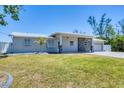 Charming single story home with a well-maintained lawn, stone accents, and a white picket fence at 150 Crestview Dr, Englewood, FL 34223