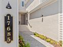 Inviting entrance with a paved walkway, landscaped garden beds, and clear view of the home's address at 17685 Boracay Ct # 202, Venice, FL 34293