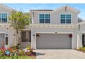 Charming home featuring a two-car garage, well-maintained landscaping, and a welcoming entrance with flowers at 17685 Boracay Ct # 202, Venice, FL 34293