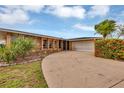 Single story home with a circular driveway, well-maintained lawn, and attached garage at 18 Annapolis Ln, Rotonda West, FL 33947