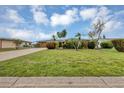 Manicured front lawn of a charming home with vibrant tropical landscaping and a circular driveway at 18 Annapolis Ln, Rotonda West, FL 33947