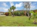 Home exterior featuring a green lawn and lush tropical landscaping at 18 Annapolis Ln, Rotonda West, FL 33947