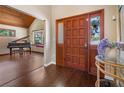 Elegant foyer with hardwood floors, a wooden door, and a view into the living room with a piano at 2020 E Dolphin Dr, Englewood, FL 34223
