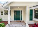 Attractive front entrance featuring a dark green door, classic sidelights, and stylish exterior lighting at 2020 E Dolphin Dr, Englewood, FL 34223