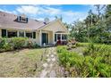 Inviting home exterior with a stepping stone pathway, lush garden, and vibrant flowers at 2020 E Dolphin Dr, Englewood, FL 34223